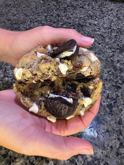 Cookies-and-cream cookie split open with sandwich-cookie pieces and white chips.