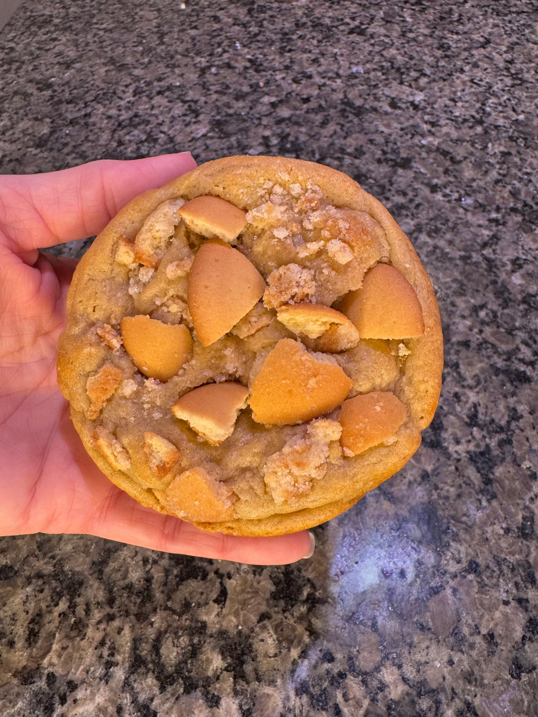 An Epic Dough cookie held in one hand for scale