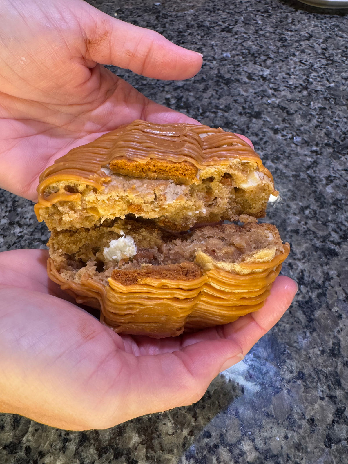 Caramel-drizzled cookie split open to show its layered, soft center.