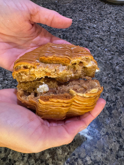 Caramel-drizzled cookie split open to show its layered, soft center.